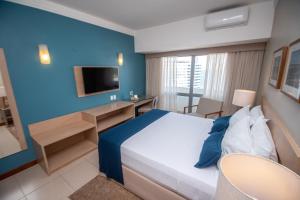 a hotel room with a bed and a tv at Portobello Ondina Praia in Salvador