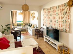 a living room with a couch and a tv at Alcudia Smir Complex piedras del Mar in Fnidek