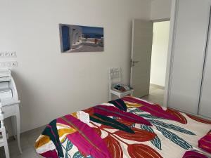 una camera da letto con un letto con una coperta colorata sopra di Appartement 48m2 jardin et terrasse a La Roche-Blanche