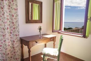 a desk and a window with a table and a chair at Appartamenti Morcone - Goelba in Capoliveri