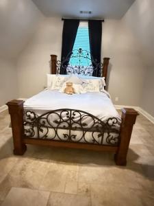 a teddy bear sitting on a bed with a window at Hidden Stables on Chancey Pond Rentals, LLC in Aiken