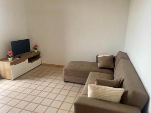 a living room with a couch and a tv at Casa DeA in Giardini Naxos