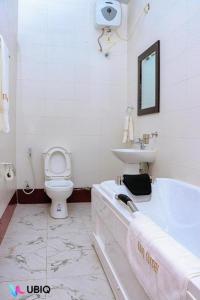 ein Badezimmer mit Badewanne, Toilette und Waschbecken in der Unterkunft Ubiq Suites and Apartments - Abuja in Abuja + 26 Fotos