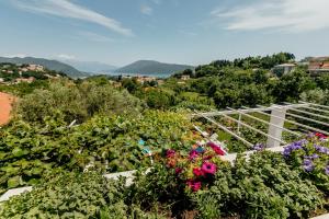 a garden with flowers and a white fence at Bella Apartments in Sušići +49 photos