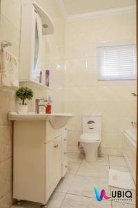 ein weißes Badezimmer mit Waschbecken und Toilette in der Unterkunft Ubiq Suites and Apartments - Abuja in Abuja