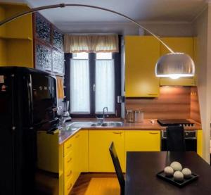 kuchnia z żółtymi szafkami i czarną lodówką w obiekcie VFH Stylish Boutique Apartment-City Center w Mediolanie +14 zdjęć