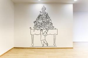 a man holding a christmas tree on a wall at Super Townhouse Prithvi Resort Near Phoenix Palassio in Lucknow
