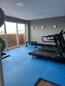 a gym with treadmills and a blue gym floor at Flat Samba Bossa Nova in Cabo Frio