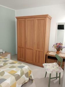 a bedroom with a wooden cabinet and a bed and a chair at Casa Cecilia in Polizzi Generosa +11 photos