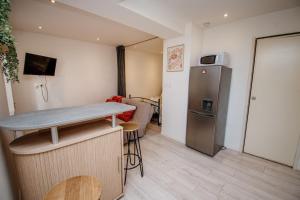 a small kitchen with a table and a refrigerator at Ecrin Pontissalien - Studio with Parking in Pontarlier