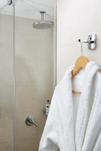 a towel hanging on the side of a shower curtain at The Westbridge Hotel Stratford in London