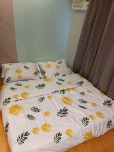 a bed with a white comforter with oranges at Great Location, Swimming pool, Shops, Staycation in Iloilo City +19 photos