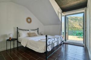 ein Schlafzimmer mit einem Bett und einem Balkon in der Unterkunft Waterfront house overlooking Kotor Bay by MN Property in Donji Stoliv
