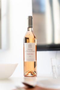 a bottle of wine sitting on a table at Escale Toulonnaise - Cosy, calme & bien situé in Toulon +14 photos