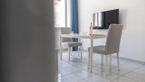 a dining room table with chairs and a television at Escale Toulonnaise - Cosy, calme & bien situé in Toulon