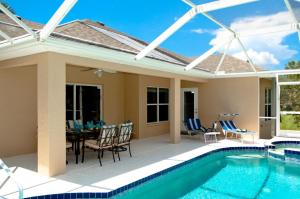 a patio with a pool and a table and chairs at Beach Bliss in Bradenton