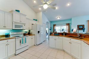 a large kitchen with white appliances and blue walls at Beach Bliss in Bradenton