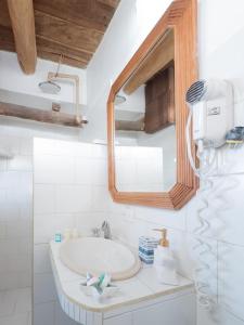 a white bathroom with a sink and a mirror at Casa Turquesa in Los Roques