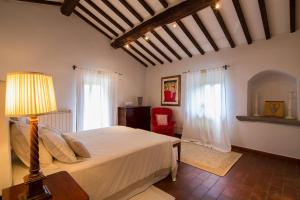 een slaapkamer met een bed met een lamp en een stoel bij Villa Valerie in Cortona