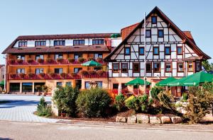 un gran edificio con sombrillas verdes delante en Danner´s Hotel Löwen, en Marschalkenzimmern