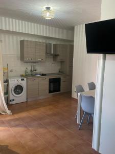 una cucina con lavatrice e tavolo con sedie di Casa vacanza Foceverde lido a Lido di Latina