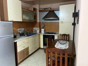 a small kitchen with a table and a refrigerator at Simple Apartment in Orikum