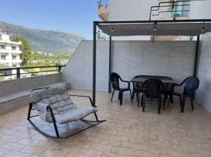 a patio with a table and chairs on a roof at Simple Apartment in Orikum