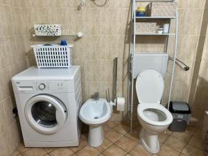 a bathroom with a washing machine and a toilet at Simple Apartment in Orikum
