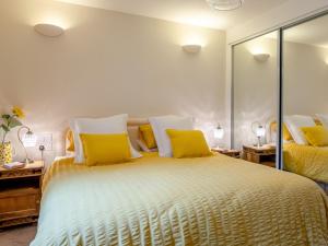 Un dormitorio con una cama grande con almohadas amarillas. en 2 Bed in Axminster 79208, en Axminster