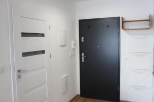 a black door in a room with white cabinets at B50 Trzy Lipki - Apartament Bielsko - WGH Rent in Bielsko-Biala