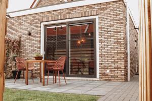 a patio with a table and chairs in front of a building at WadZinnig in Hollum