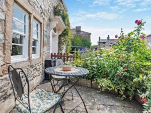 a patio with a table and chairs and flowers at 1 Bed in Ashford in the Water PK249 in Great Longstone