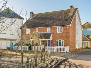 a large red brick house with a white fence at 3 Bed in Camber BT011 in Camber