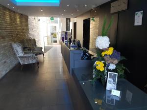 a lobby with a counter with flowers on it at The Westbridge Hotel Stratford in London