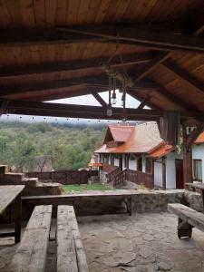 a pavilion with wooden picnic tables in front of a building at Renovated traditional house - Rustic Escape in Şapartoc +9 photos