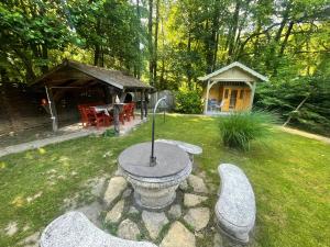 Kispatak Erdei Ház في Kismaros: حديقة مع طاولة حجرية وشرفة