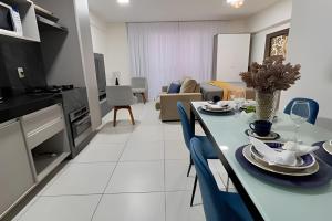 Una cocina y una sala de estar con mesa y sillas. en Edf Time 1503 | Piscina | Academia | Jacuzzi, en Maceió