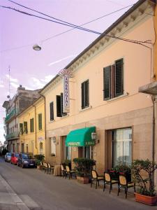モンテカティーニ・テルメにあるHotel Ambroginiの通りにテーブルと椅子が並ぶ建物