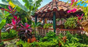 a garden with a gazebo with flowers and plants at El Gran Boga in Villeta