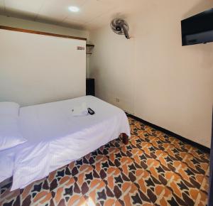 a room with a bed and a tv and a floor at El Gran Boga in Villeta