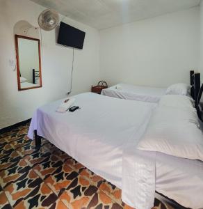 a white bed in a room with a mirror at El Gran Boga in Villeta +54 photos