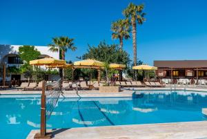a large swimming pool with umbrellas and chairs at Gaia Garden in Kos