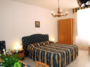 モンテカティーニ・テルメにあるHotel Ambroginiのベッドルーム1室(ベッド1台、椅子付)