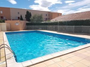 einem Pool mit blauem Wasser vor einem Gebäude in der Unterkunft Villa bord de mer in Gruissan