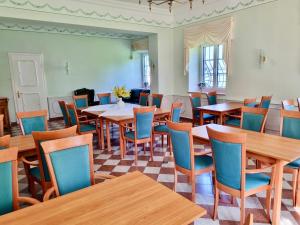 a dining room with wooden tables and chairs at Schloss Elmischwang in Fischach