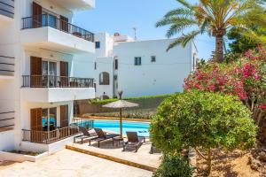 a villa with a swimming pool and palm trees at Gran Sol Family 7 in Felanitx