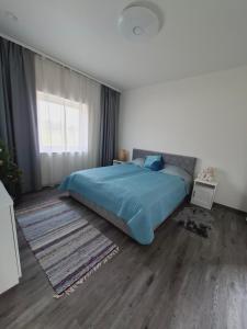 a bedroom with a blue bed and a window at Sõbra SPA Villa Haapsalu lähistel kaunis looduses in Nõmme
