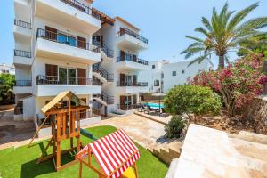 apartament z placem zabaw przed budynkiem w obiekcie Gran Sol Family 6 w mieście Felanitx