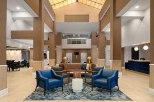 a lobby with blue chairs and a waiting area at DoubleTree by Hilton Norfolk Airport in Norfolk