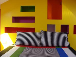 een slaapkamer met een bed met een kleurrijke muur bij La cajita feliz in Alghero